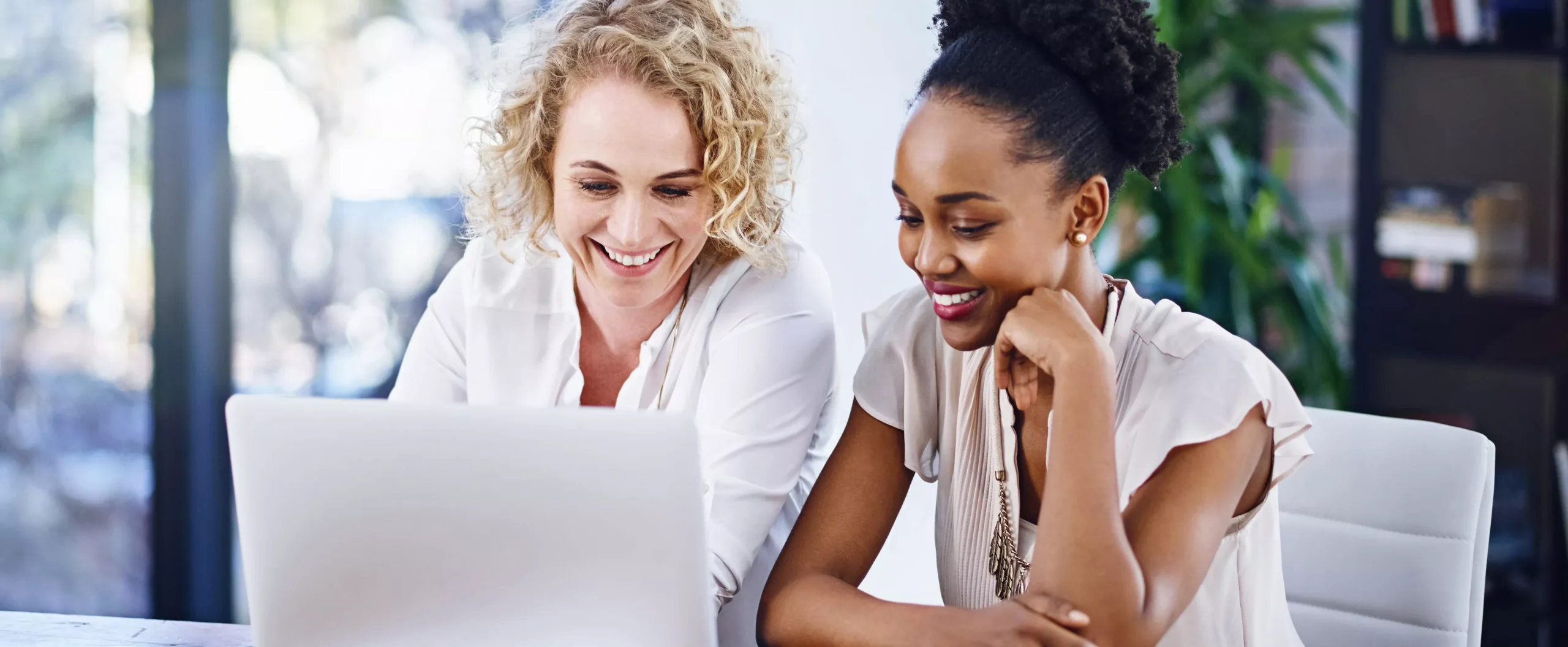 Two women looking at a computer screen together