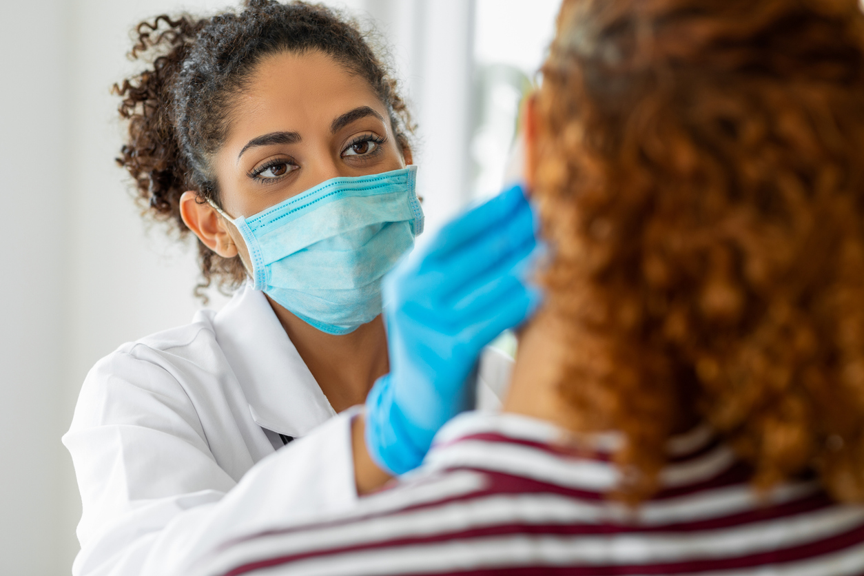 Dentist wearing a mask and working with a patient.